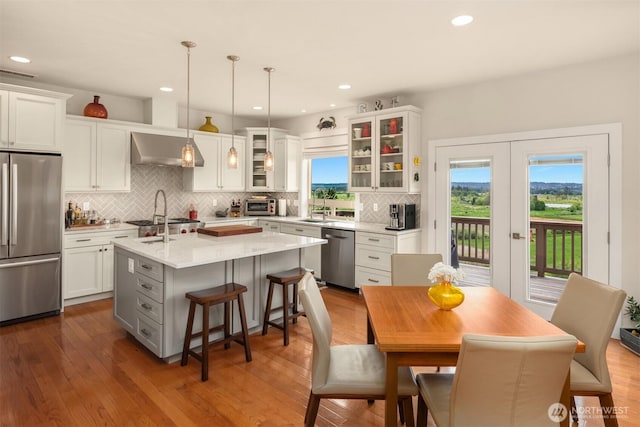 1032 76th Ave NE, Lake Stevens, WA 98258 - kitchen featuring stainless steel appliances, a kitchen island with sink, light countertops, decorative backsplash, and white cabinets