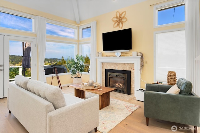 95 Martingale Pl, Port Ludlow, WA 98365 - living room with plenty of natural light, a glass covered fireplace, beamed ceiling, wood finished floors, and high vaulted ceiling