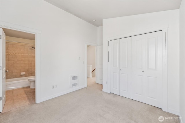 9503 Ashworth Ave N Unit B, Seattle, WA 98103 - unfurnished bedroom featuring carpet, a closet, ensuite bath, and tile patterned floors