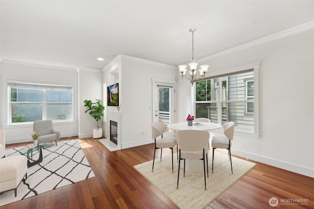 9503 Ashworth Ave N Unit B, Seattle, WA 98103 - dining space featuring crown molding, a chandelier, wood finished floors, a fireplace with flush hearth, and recessed lighting