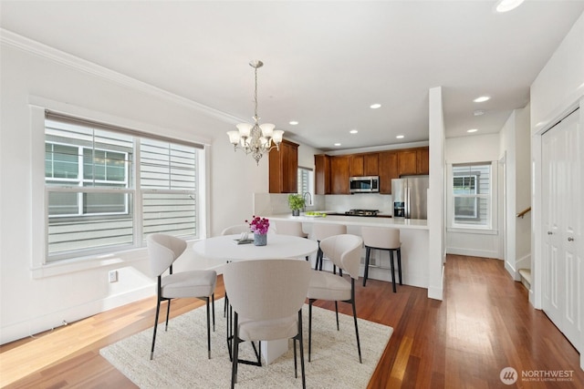 9503 Ashworth Ave N Unit B, Seattle, WA 98103 - dining area with a chandelier, wood finished floors, crown molding, recessed lighting, and stairs