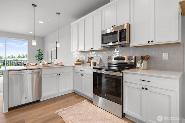 15726 40th Ave W Unit A6, Lynnwood, WA 98087 - kitchen featuring stainless steel appliances, light wood-type flooring, a peninsula, decorative backsplash, and recessed lighting