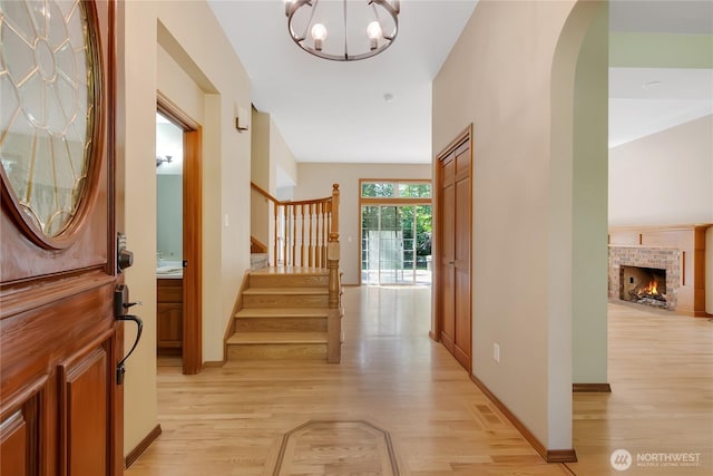 3941 16th Ln NE, Olympia, WA 98506 - foyer with light wood finished floors, a chandelier, stairway, and a fireplace