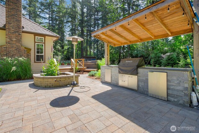 3941 16th Ln NE, Olympia, WA 98506 - view of patio / terrace featuring an outdoor kitchen, a deck, and view of scattered trees