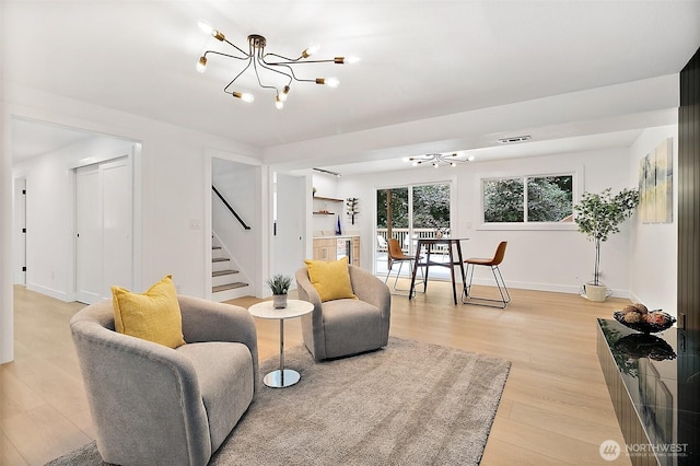6347 121st Ave SE, Bellevue, WA 98006 - living room with a chandelier, stairway, and light wood-style flooring