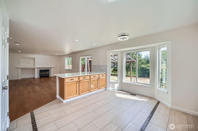 15223 SE 276th Pl, Kent, WA 98042 - kitchen featuring light countertops, a peninsula, plenty of natural light, a glass covered fireplace, and recessed lighting