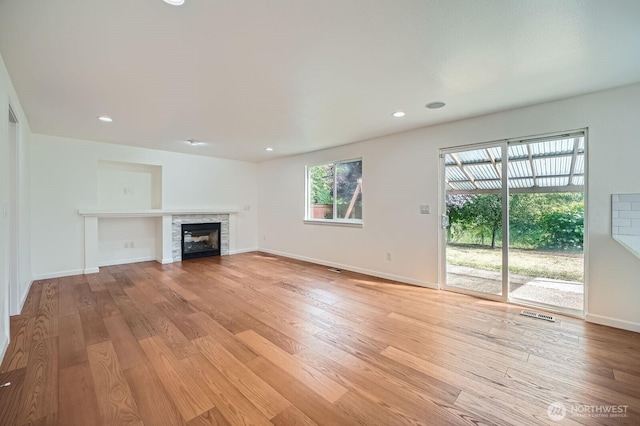 15223 SE 276th Pl, Kent, WA 98042 - unfurnished living room featuring light wood-type flooring, a glass covered fireplace, and recessed lighting