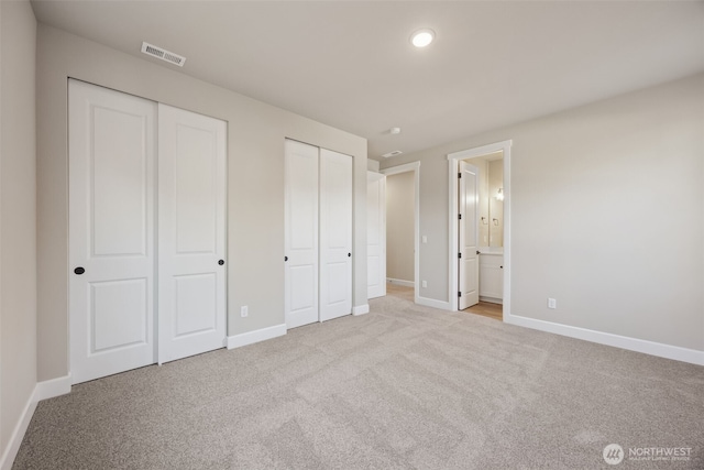 10630 134th Dr NE Unit 112, Lake Stevens, WA 98258 - unfurnished bedroom featuring two closets, light colored carpet, and ensuite bathroom