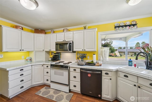910 Crestline Dr, Longview, WA 98632 - kitchen with dishwashing machine, white electric range oven, stainless steel microwave, tile countertops, and crown molding