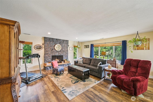 910 Crestline Dr, Longview, WA 98632 - living room with wood finished floors, a stone fireplace, recessed lighting, and a textured ceiling