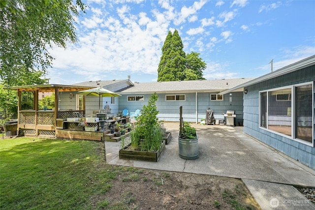 910 Crestline Dr, Longview, WA 98632 - back of property with a lawn, a patio area, and a vegetable garden