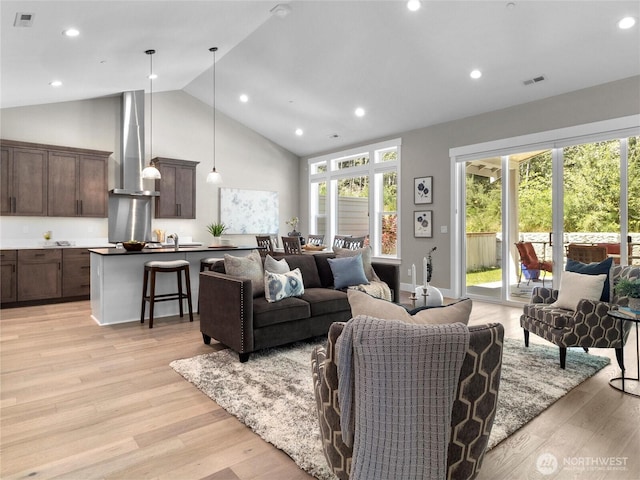 13809 119th Street Ct NW, Gig Harbor, WA 98329 - living area with high vaulted ceiling, healthy amount of natural light, light wood finished floors, and recessed lighting