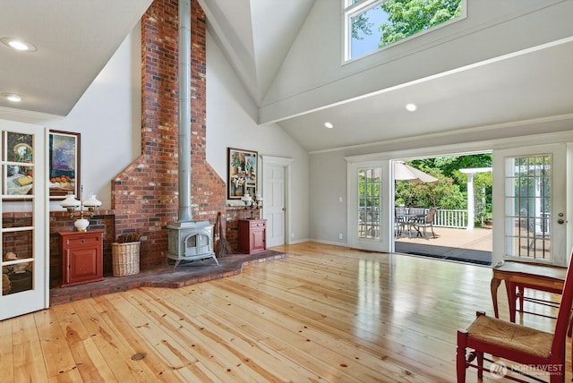 909 308th St NE, Stanwood, WA 98282 - unfurnished living room featuring a wood stove, hardwood / wood-style flooring, high vaulted ceiling, and recessed lighting