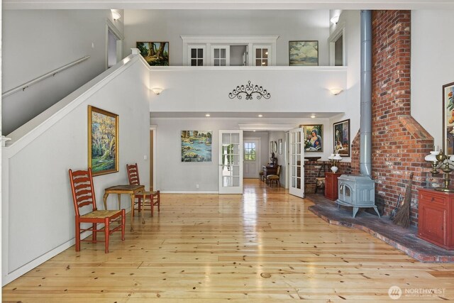 909 308th St NE, Stanwood, WA 98282 - foyer with hardwood / wood-style floors, a wood stove, french doors, and a high ceiling