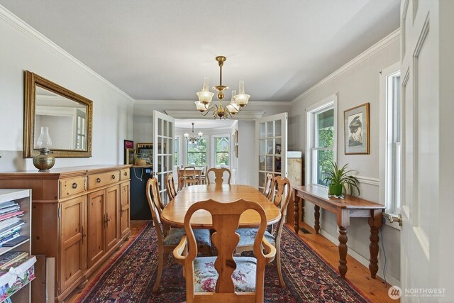 909 308th St NE, Stanwood, WA 98282 - dining space with a chandelier, dark wood-type flooring, and ornamental molding