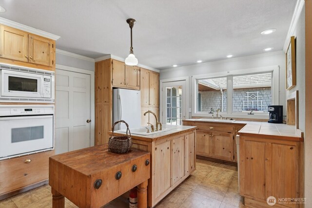 909 308th St NE, Stanwood, WA 98282 - kitchen featuring white appliances, ornamental molding, tile counters, a center island with sink, and recessed lighting