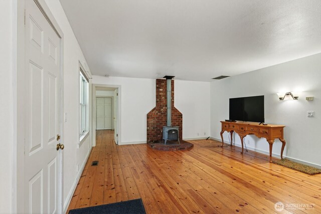 909 308th St NE, Stanwood, WA 98282 - living area featuring a wood stove and light wood-style flooring