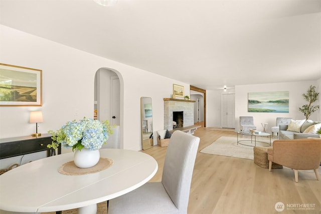 16740 Dunbar Rd, Mount Vernon, WA 98273 - dining room with arched walkways, light wood finished floors, and a fireplace with raised hearth