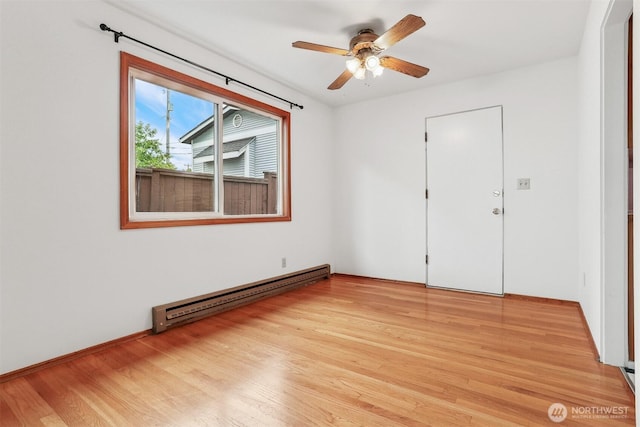1919 2nd Ave W, Seattle, WA 98119 - unfurnished room featuring a baseboard radiator, light wood-type flooring, and a ceiling fan