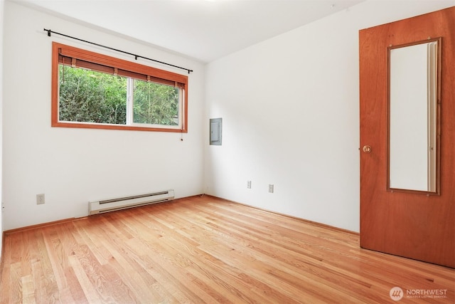 1919 2nd Ave W, Seattle, WA 98119 - unfurnished room featuring a baseboard radiator, wood finished floors, and electric panel