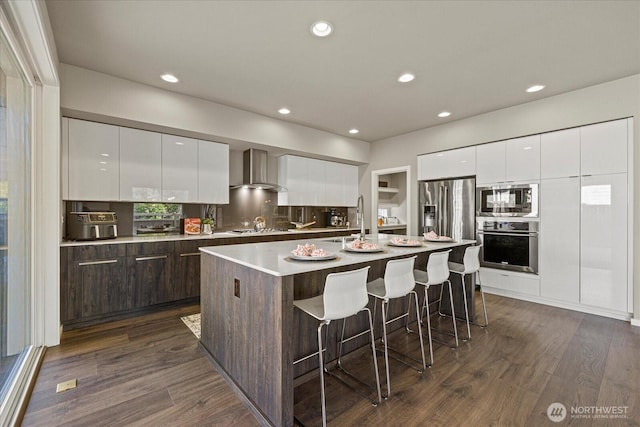 35404 55th Ave S, Auburn, WA 98001 - kitchen with modern cabinets, appliances with stainless steel finishes, wall chimney exhaust hood, a breakfast bar area, and white cabinets