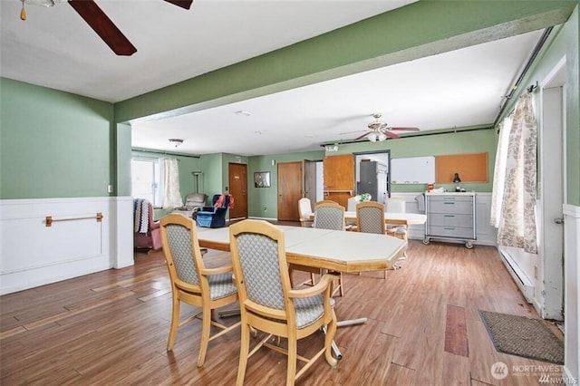 715 Locust St, Omak, WA 98841 - dining room featuring a ceiling fan, light wood-style flooring, and wainscoting