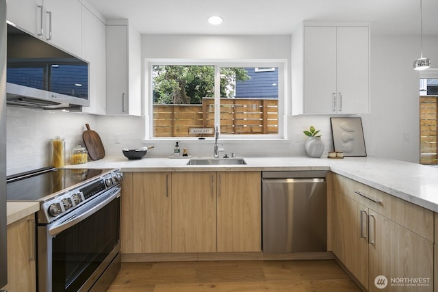 3422 20th Ave S, Seattle, WA 98144 - kitchen featuring stainless steel appliances, light wood-style flooring, backsplash, light stone counters, and recessed lighting