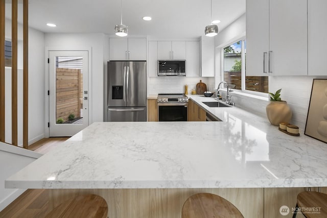 3422 20th Ave S, Seattle, WA 98144 - kitchen featuring stainless steel appliances, light stone counters, tasteful backsplash, a peninsula, and recessed lighting