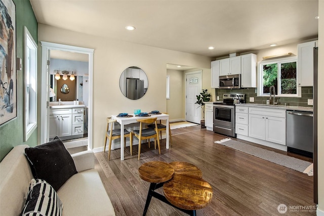 8430 34th Ave S, Seattle, WA 98118 - kitchen with appliances with stainless steel finishes, dark wood finished floors, white cabinetry, and recessed lighting