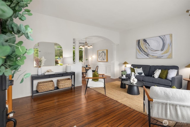 23618 Carter Rd, Bothell, WA 98021 - living room with arched walkways, ornate columns, a chandelier, and hardwood / wood-style floors
