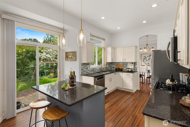 23618 Carter Rd, Bothell, WA 98021 - kitchen with backsplash, dark wood finished floors, white cabinetry, dark stone countertops, and a kitchen bar