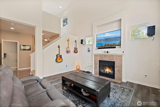 16922 SE 262nd St, Covington, WA 98042 - living room featuring a tile fireplace, wood finished floors, stairway, a towering ceiling, and recessed lighting