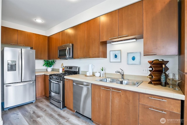 1214 N Northgate Way, Seattle, WA 98133 - kitchen with stainless steel appliances, light countertops, brown cabinetry, and light wood-style flooring