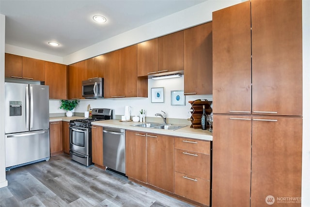 1214 N Northgate Way, Seattle, WA 98133 - kitchen featuring appliances with stainless steel finishes, light countertops, brown cabinetry, light wood-style flooring, and recessed lighting