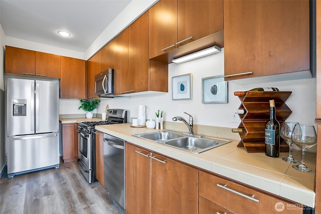 1214 N Northgate Way, Seattle, WA 98133 - kitchen featuring appliances with stainless steel finishes, brown cabinets, wood finished floors, and recessed lighting
