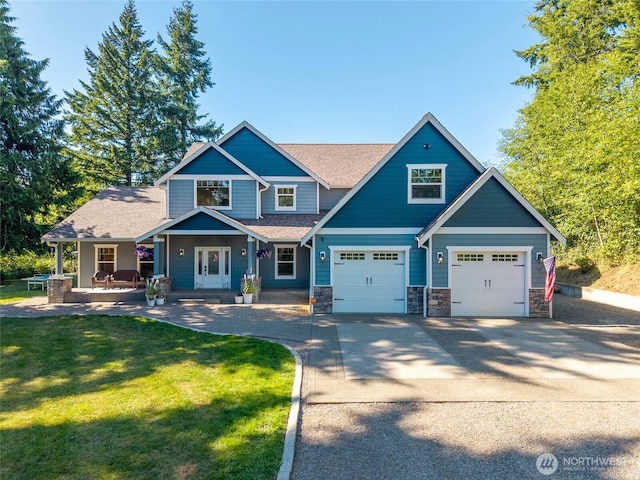 19838 Bear View Ln SW, Rochester, WA 98579 - craftsman house featuring covered porch, a front lawn, concrete driveway, stone siding, and roof with shingles