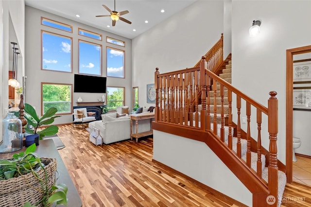 19838 Bear View Ln SW, Rochester, WA 98579 - living room featuring a high ceiling, a ceiling fan, a fireplace, recessed lighting, and stairs
