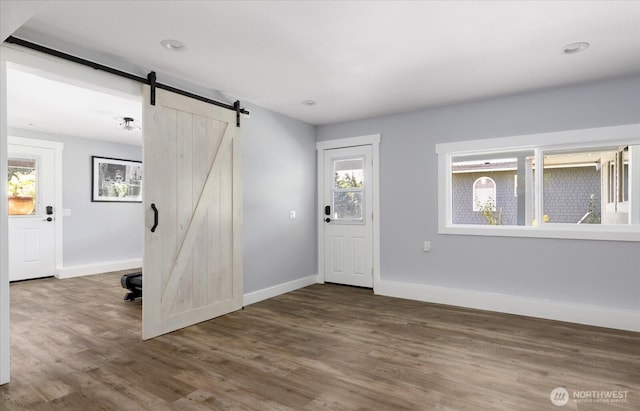 2735 Evening Glory Ct, Clinton, WA 98236 - entrance foyer featuring a barn door, plenty of natural light, and wood finished floors