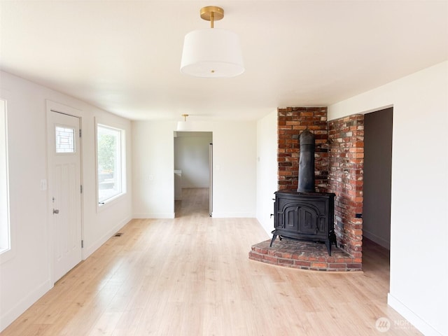 308 N Dale Rd, Moses Lake, WA 98837 - unfurnished living room featuring light wood-style flooring and a wood stove