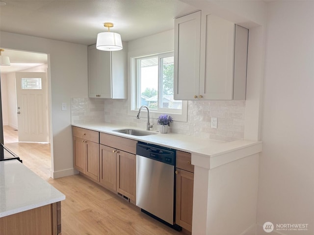 308 N Dale Rd, Moses Lake, WA 98837 - kitchen with stainless steel dishwasher, light wood-style flooring, decorative backsplash, light countertops, and hanging light fixtures