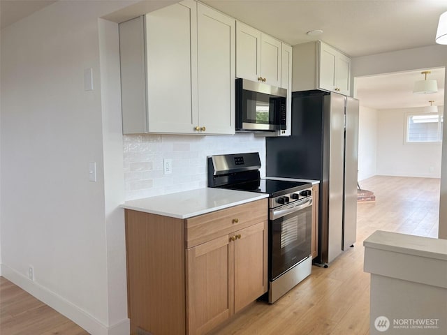 308 N Dale Rd, Moses Lake, WA 98837 - kitchen with stainless steel appliances, light wood-style flooring, backsplash, and light countertops