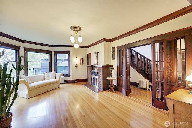 906 E Shelby St, Seattle, WA 98102 - living area featuring radiator heating unit, light wood finished floors, stairway, crown molding, and a fireplace