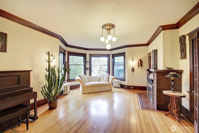 906 E Shelby St, Seattle, WA 98102 - living area with radiator heating unit, wood finished floors, ornamental molding, a brick fireplace, and a chandelier