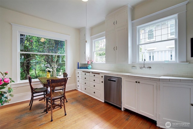906 E Shelby St, Seattle, WA 98102 - kitchen featuring dishwasher, white cabinetry, wood-type flooring, and backsplash