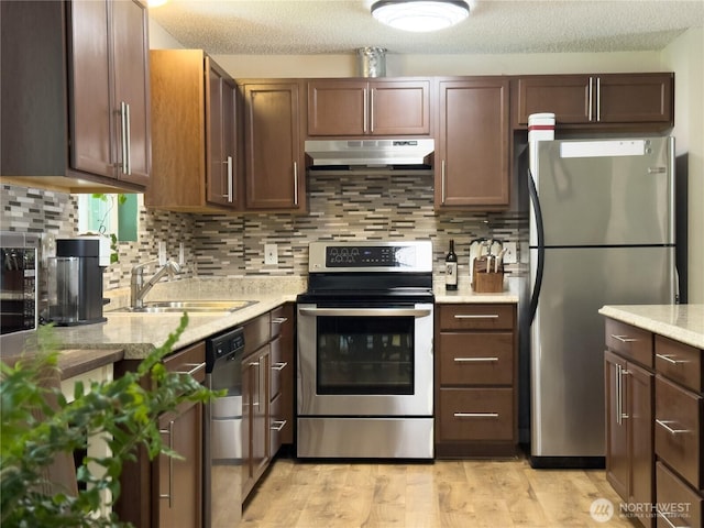 17714 Robinhood Ln, Snohomish, WA 98290 - kitchen with stainless steel appliances, under cabinet range hood, tasteful backsplash, light wood-type flooring, and a textured ceiling