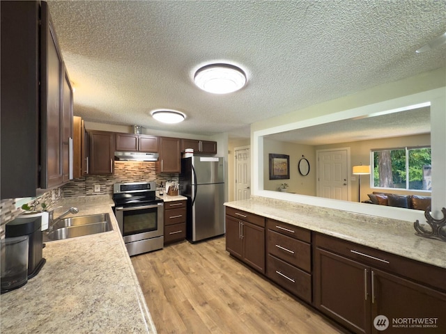 17714 Robinhood Ln, Snohomish, WA 98290 - kitchen with appliances with stainless steel finishes, under cabinet range hood, light countertops, a textured ceiling, and decorative backsplash