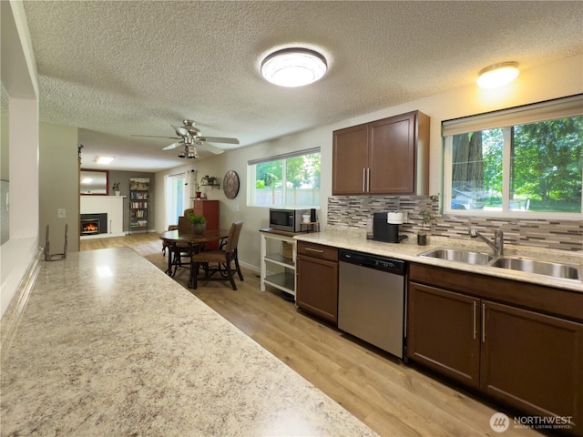 17714 Robinhood Ln, Snohomish, WA 98290 - kitchen with appliances with stainless steel finishes, a textured ceiling, light countertops, ceiling fan, and a warm lit fireplace