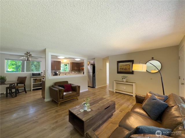 17714 Robinhood Ln, Snohomish, WA 98290 - living room featuring a textured ceiling, light wood-style flooring, and ceiling fan
