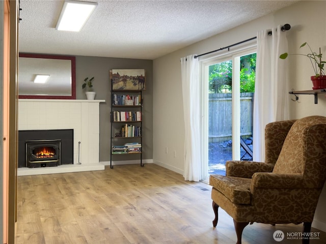 17714 Robinhood Ln, Snohomish, WA 98290 - living area featuring a textured ceiling, wood finished floors, and a lit fireplace