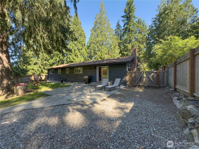 17714 Robinhood Ln, Snohomish, WA 98290 - rear view of property featuring a patio, a fenced backyard, a chimney, and a gate